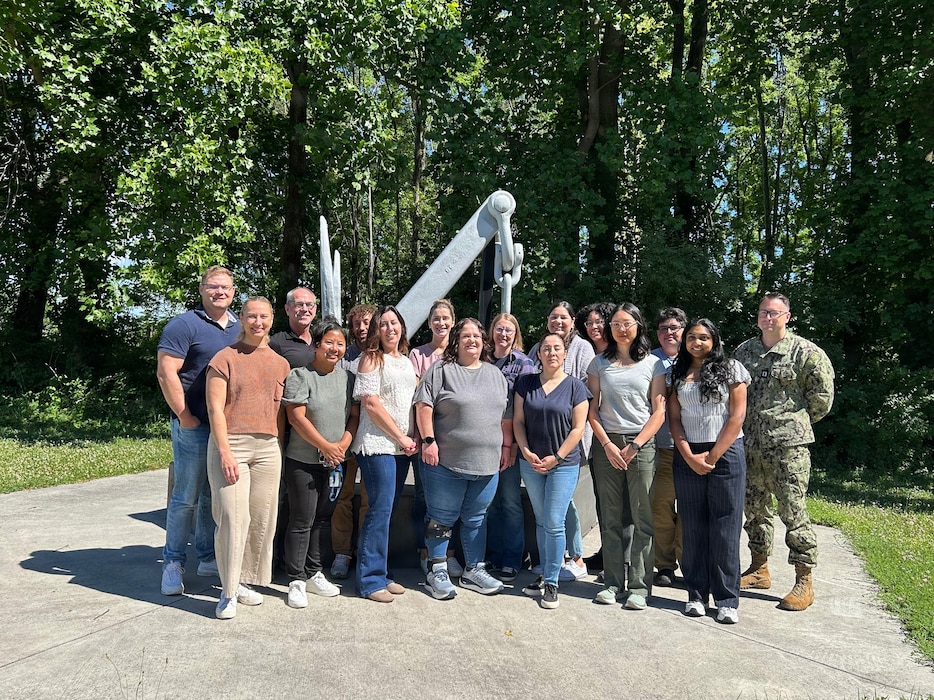 FREDERICK, Md. (June 16, 2026) Kimberly Bishop-Lilly (first row, third from left) poses for a photo with members of Naval Medical Research Command’s (NMRC) Genomics & Bioinformatics Department. Bishop-Lilly was selected as a recipient of the Assistant Secretary of the Navy (Research, Development and Acquisition) 2026 Dr. Delores M. Etter Top Scientists and Engineers of the Year Award in the Individual Scientist category. NMRC, headquarters of Navy Medicine Research & Development, is engaged in a broad spectrum of activity from basic science in the laboratory to field studies in austere and remote areas of the world to investigations in operational environments. In support of Navy, Marine Corps and joint U.S. warfighter health, readiness and lethality, researchers study infectious diseases, biological warfare detection and defense, combat casualty care, environmental health concerns, aerospace and undersea medicine, operational mission support and epidemiology. Navy Medicine’s 44,000+ talented and ready forces optimize health readiness, deliver quality healthcare and provide global expeditionary medical support to warfighters. (U.S. Navy photo by Deirdre Coffey/released)