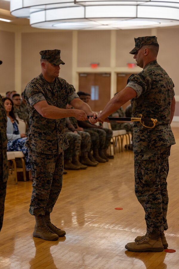 U.S. Marine Corps Sgt. Maj. Casey S. Chandler, left, outgoing senior enlisted leader for 2nd Network Battalion, Marine Corps Cyberspace Operations Group, passes the sword of office to Lt. Col. Glenn Berdela Jr., commanding officer, 2nd Network Bn, MCCOG, during a relief and appointment ceremony at Marine Corps Base Camp Lejeune, North Carolina, June 2, 2026. 2nd Network Bn held the ceremony to mark the transition of its senior enlisted leadership, signifying the transfer of all responsibilities and authorities between the outgoing and incoming sergeants major. (U.S. Marine Corps Photo by Cpl. Jessica J. Mazzamuto)