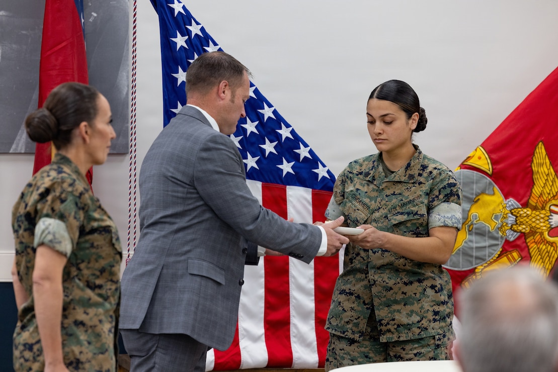 Retired U.S. Marine Corps Lt. Col. Karl W. Schlegel, center, the first commanding officer of 2nd Network Battalion, Marine Corps Cyberspace Operations Group, hands a slice of cake to Sgt. Mera N. Creamer, admin clerk, 2nd Network Battalion, MCCOG, during 2nd Network Bn’s 5th birthday ceremony at Marine Corps Base Camp Lejeune, North Carolina, June 3, 2026. 2nd Network Bn was activated on June 3, 2021, to ensure the operation of a resilient network that enables mission execution in the face of persistent cyber threats. (U.S. Marine Corps photo by Lance Cpl. Alyssa J. DeCrane)