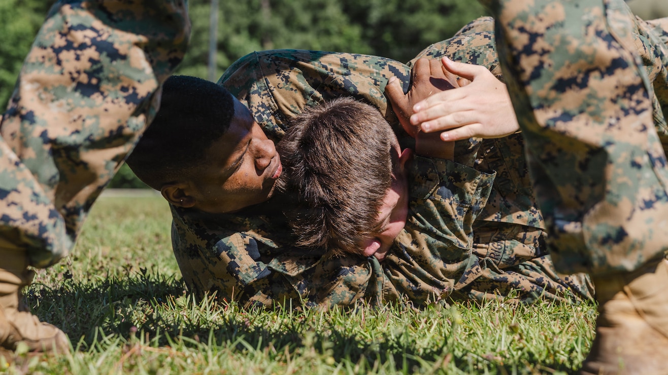 U.S. Marine Corps Cpl. Nathaniel Lewis, left, supply administrative specialist, 2nd Network Battalion, Marine Corps Cyberspace Operations Group, Marine Corps Forces Cyberspace Command, executes a rear choke during 2nd Network Battalion’s 5th birthday celebration at Marine Corps Base Camp Lejeune, North Carolina, June 4, 2026. 2nd Network Battalion was activated on June 3, 2021, to ensure the operation of a resilient network that enables mission execution in the face of persistent cyber threats. (U.S. Marine Corps photo by Cpl Daniela Chicas Torres)