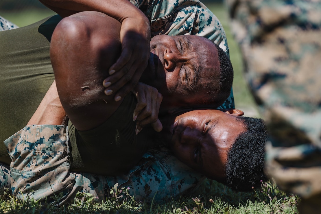 U.S. Marine Corps Sgt. Handy Dorleus, below, assistant technical evaluation chief, 2nd Network Battalion, Marine Corps Cyberspace Operations Group, Marine Corps Forces Cyberspace Command, executes a rear choke during 2nd Network Battalion’s 5th birthday ceremony at Marine Corps Base Camp Lejeune, North Carolina, June 4, 2026. 2nd Network Battalion was activated on June 3, 2021, to ensure the operation of a resilient network that enables mission execution in the face of persistent cyber threats. (U.S. Marine Corps photo by Cpl Daniela Chicas Torres)