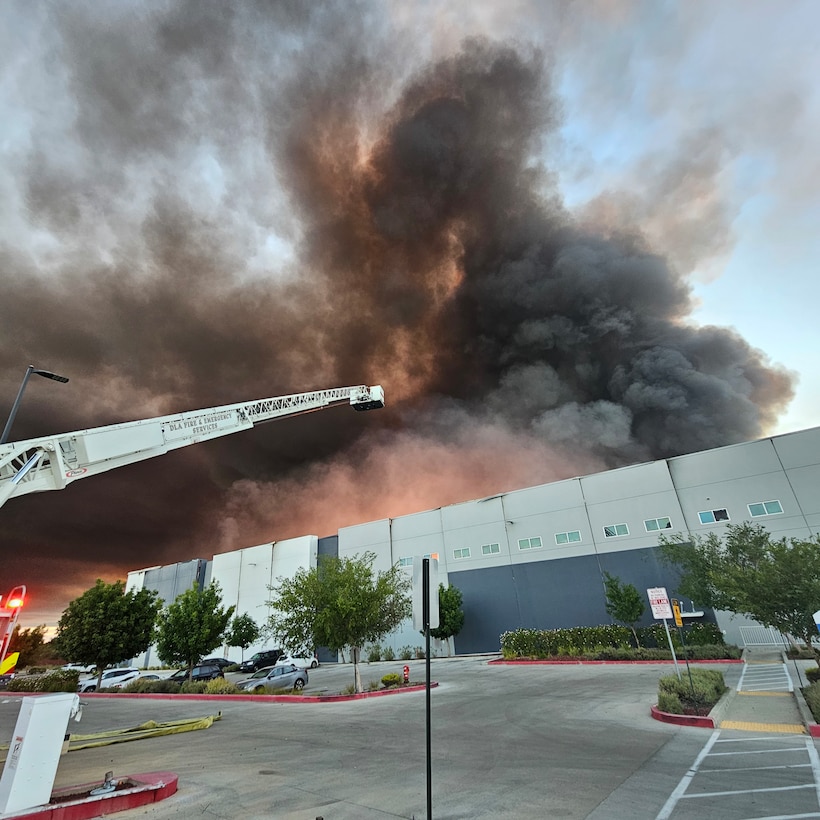 Firefighters from Defense Logistics Agency Installation Management, San Joaquin Fire & Emergency Services battle a large fire.