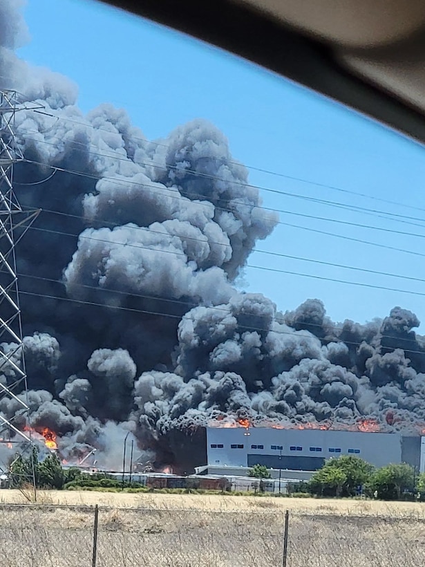 Firefighters from Defense Logistics Agency Installation Management, San Joaquin Fire & Emergency Services battle a large fire.