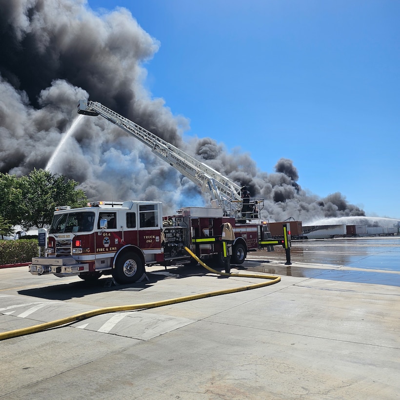 Firefighters from Defense Logistics Agency Installation Management, San Joaquin Fire & Emergency Services battle a large fire.
