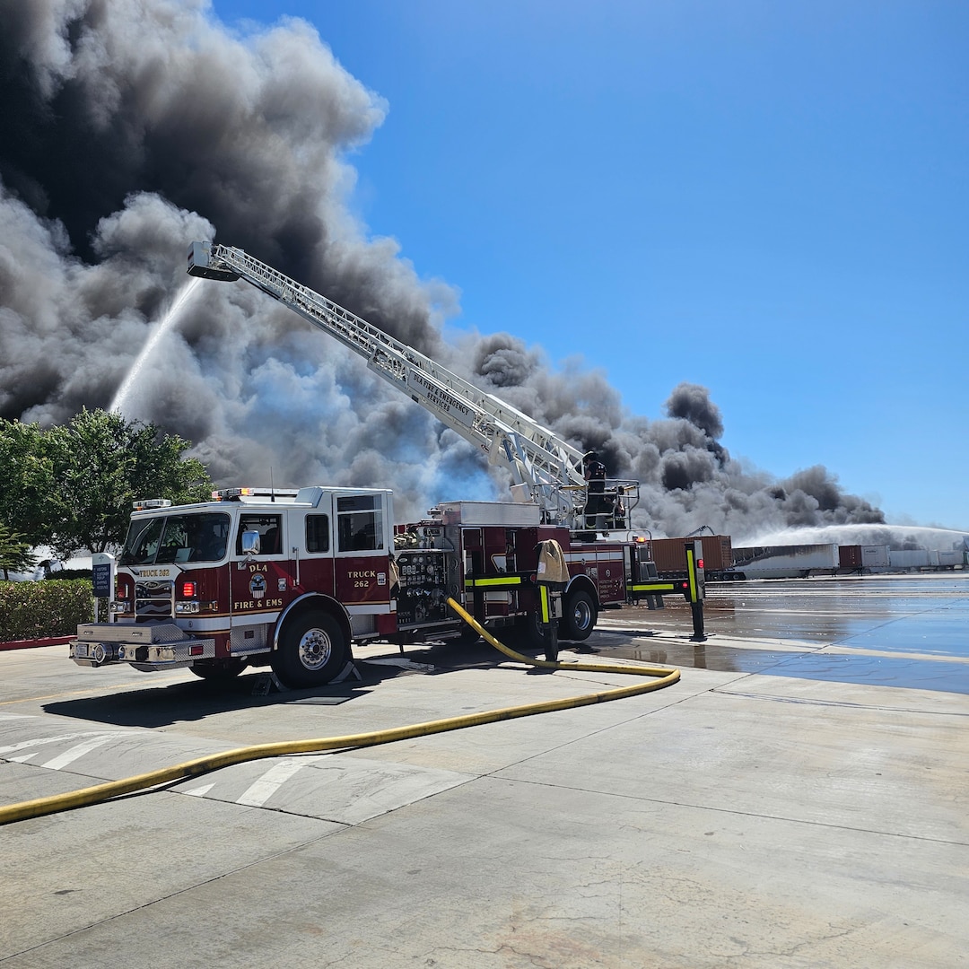 Firefighters from Defense Logistics Agency Installation Management, San Joaquin Fire & Emergency Services battle a large fire.