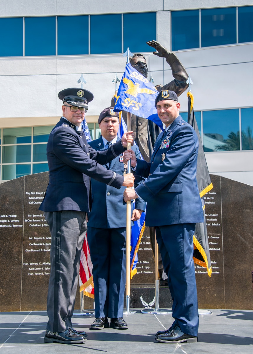 Col. Andrew C. Dermanoski, left, commander of Space Base Delta 3, presents the 61st Security Forces Squadron guidon to Capt. Joshua D. Baird, incoming commander of the 61st Security Forces Squadron, during a change of command ceremony at Los Angeles Air Force Base, California, June 12, 2026. The passing of the guidon represents Baird's assumption of command of the squadron. The 61st Security Forces Squadron provides security and force protection for four installations, supports Space Systems Command's $10 billion acquisition mission and serves more than 600 military families. (U.S. Space Force photo by Van Ha)