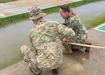 ABIDJAN, Côte d'Ivoire (April 15, 2026) Cmdr. Rebecca Pavlicek, Naval Medical Research Unit (NAMRU) EURAFCENT detachment director, collects samples from a water source as part of environmental health surveillance activities during exercise Flintlock 2026. These efforts support force health protection by identifying potential biological hazards that could impact deployed service members and mission readiness. NAMRU EURAFCENT, part of Navy Medicine Research & Development, conducts research, surveillance and studies of vaccines, therapeutic agents, diagnostic assays and vector control measures in the EUCOM, AFRICOM and CENTCOM Areas of Responsibility to better prevent and treat infectious diseases in support of Navy, Marine Corps and joint U.S. warfighter health, readiness and lethality. (U.S. Navy courtesy photo/Released)