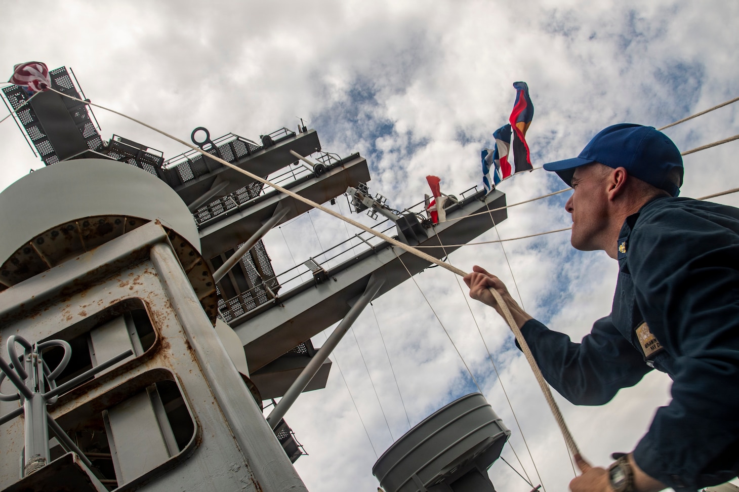Navy Quartermaster Senior Chief Benjamin Richards shifts colors on the mast of Nimitz-class aircraft USS Nimitz (CVN 68) after pulling pierside at Naval Station Mayport in Jacksonville, Florida, June 16, 2026. Nimitz is underway in the U.S. 2nd Fleet area of operations as part of a scheduled homeport shift to Norfolk, Virginia.  (U.S. Navy photo by Mass Communication Specialist 2nd Class Jaron Wills)