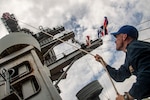 Navy Quartermaster Senior Chief Benjamin Richards shifts colors on the mast of Nimitz-class aircraft USS Nimitz (CVN 68) after pulling pierside at Naval Station Mayport in Jacksonville, Florida, June 16, 2026. Nimitz is underway in the U.S. 2nd Fleet area of operations as part of a scheduled homeport shift to Norfolk, Virginia.  (U.S. Navy photo by Mass Communication Specialist 2nd Class Jaron Wills)