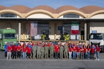 A group of people stand outside of a warehouse.