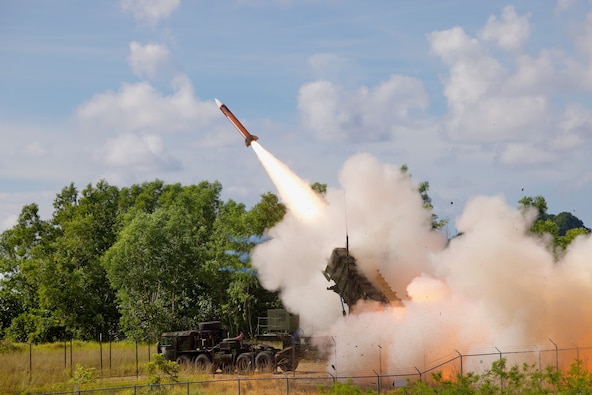 A side view of the Patriot missile atop a mobile unit, with the missile loaded and pointing at a 45 degree angle toward the sky.