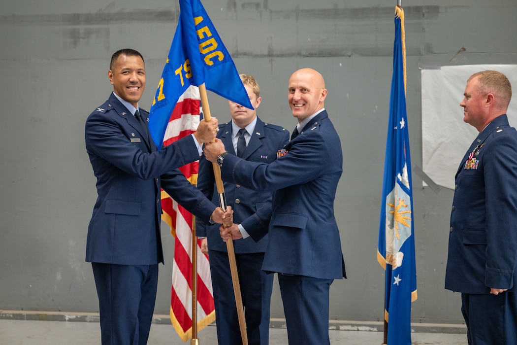 Lt. Col. Jonathan Tellefsen, center, takes the guidon from 804th Test Group Commander Col. Jack Rhodes, left, to assume the role of 717th Test Squadron commander during a June 9, 2026, Change of Leadership ceremony at Arnold Air Force Base, Tenn., headquarters of Arnold Engineering Development Complex. Also pictured is outgoing 717 TS Commander Lt. Col. Joshua Thomas. (U.S. Air Force photo by Keith Thornburgh)