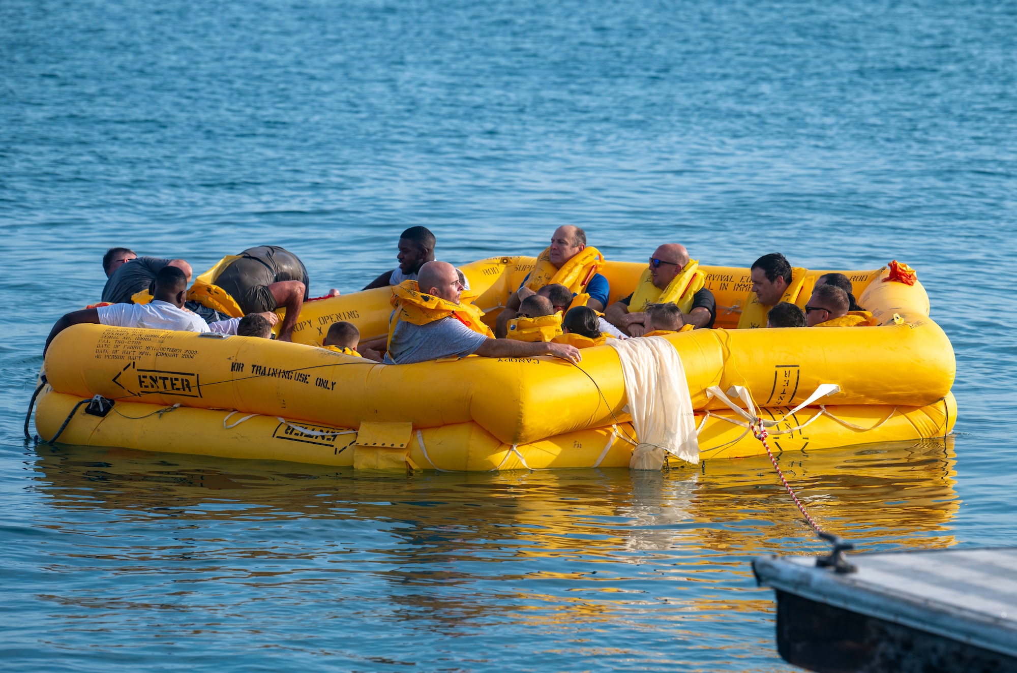 U.S. Airmen assigned to the 183rd Airlift Squadron sit inside a life raft during Aircrew Flight Equipment (AFE) Water Survival Training in Key West, Florida, June 2, 2025. The purpose of the training is to prepare service members to survive and await rescue in open water environments using techniques like life raft survival and underwater escape procedures. (U.S. Air National Guard photo by Senior Airman Damara Burrell)