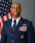 photo of USAF Airman standing in front of US flag