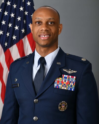 photo of USAF Airman standing in front of US flag