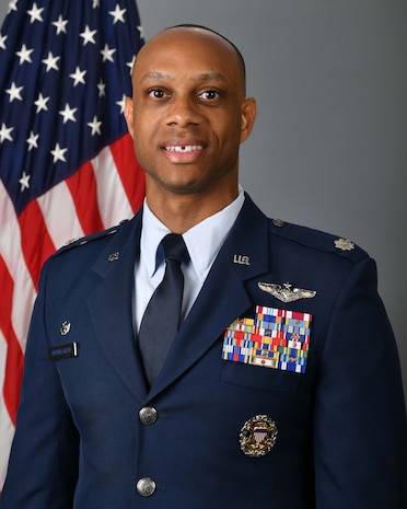 photo of USAF Airman standing in front of US flag