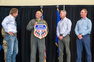 U.S. Air Force Chief Master Sgt. Lindsay Moon, former 92nd Air Refueling Wing command chief, receives a gift from former Air Force refueling specialists during his retirement ceremony at Fairchild Air Force Base, Washington, June 16, 2026.