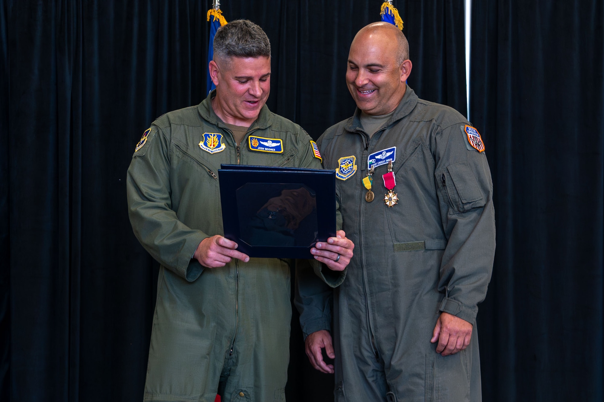 U.S. Air Force Col. Joshua Moores, left, 97th Air Mobility Wing deputy commander, presents certificate of retirement to Chief Master Sgt. Lindsay Moon, right, former 92nd Air Refueling Wing command chief, at Fairchild Air Force Base, Washington, June 16, 2026.