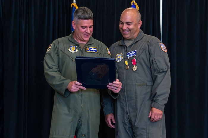 U.S. Air Force Col. Joshua Moores, left, 97th Air Mobility Wing deputy commander, presents certificate of retirement to Chief Master Sgt. Lindsay Moon, right, former 92nd Air Refueling Wing command chief, at Fairchild Air Force Base, Washington, June 16, 2026.