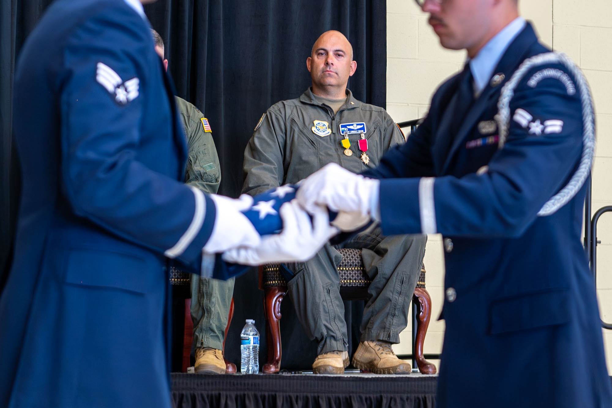 U.S. Air Force Chief Master Sgt. Lindsay Moon, former 92nd Air Refueling Wing command chief, watches a U.S. flag folding during his retirement ceremony at Fairchild Air Force Base, Washington, June 16, 2026.