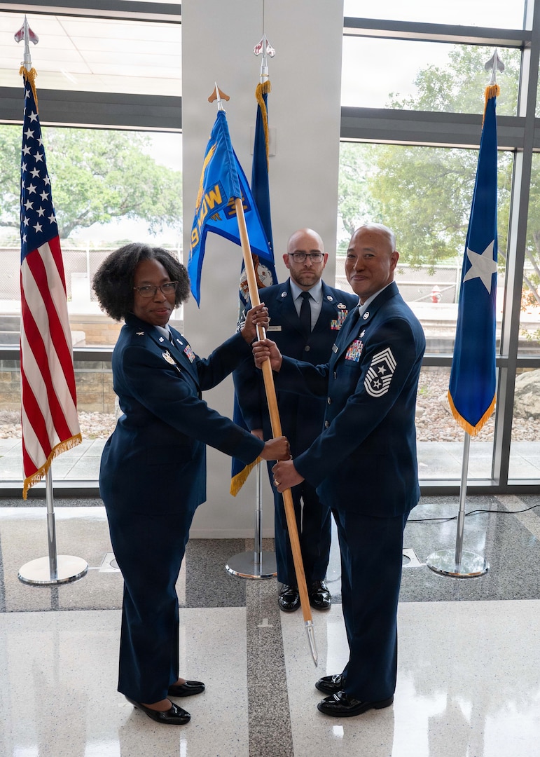 Chief Master Sgt. Harvey M. McReynolds Jr., incoming command chief of the 59th Medical Wing, receives the guidon during a Change of Responsibility Ceremony at the Wilford Hall Ambulatory Surgical Center, Joint Base San Antonio-Lackland, Texas, June 12, 2026.