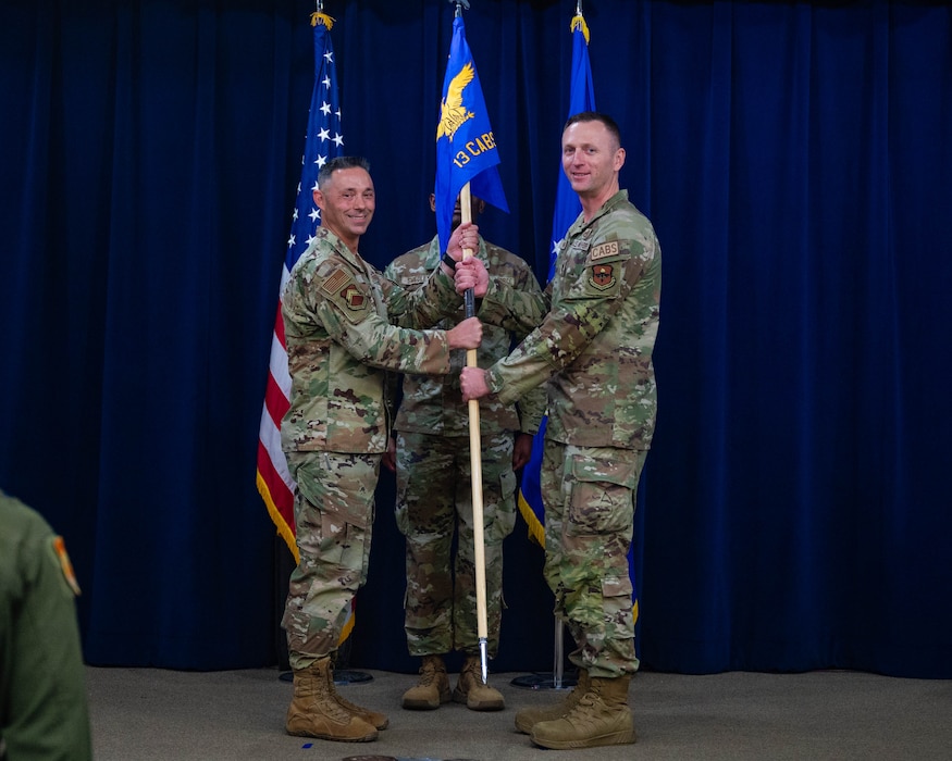 U.S. Air Force Col. Darryl Hebert, 56th Mission Support Group commander, left, receives the unit guidon from Lt. Col. Chris Bahrij, 13th Combat Air Base Squadron commander, during the squadron's inactivation ceremony at Luke Air Force Base, Arizona, June 16, 2026.