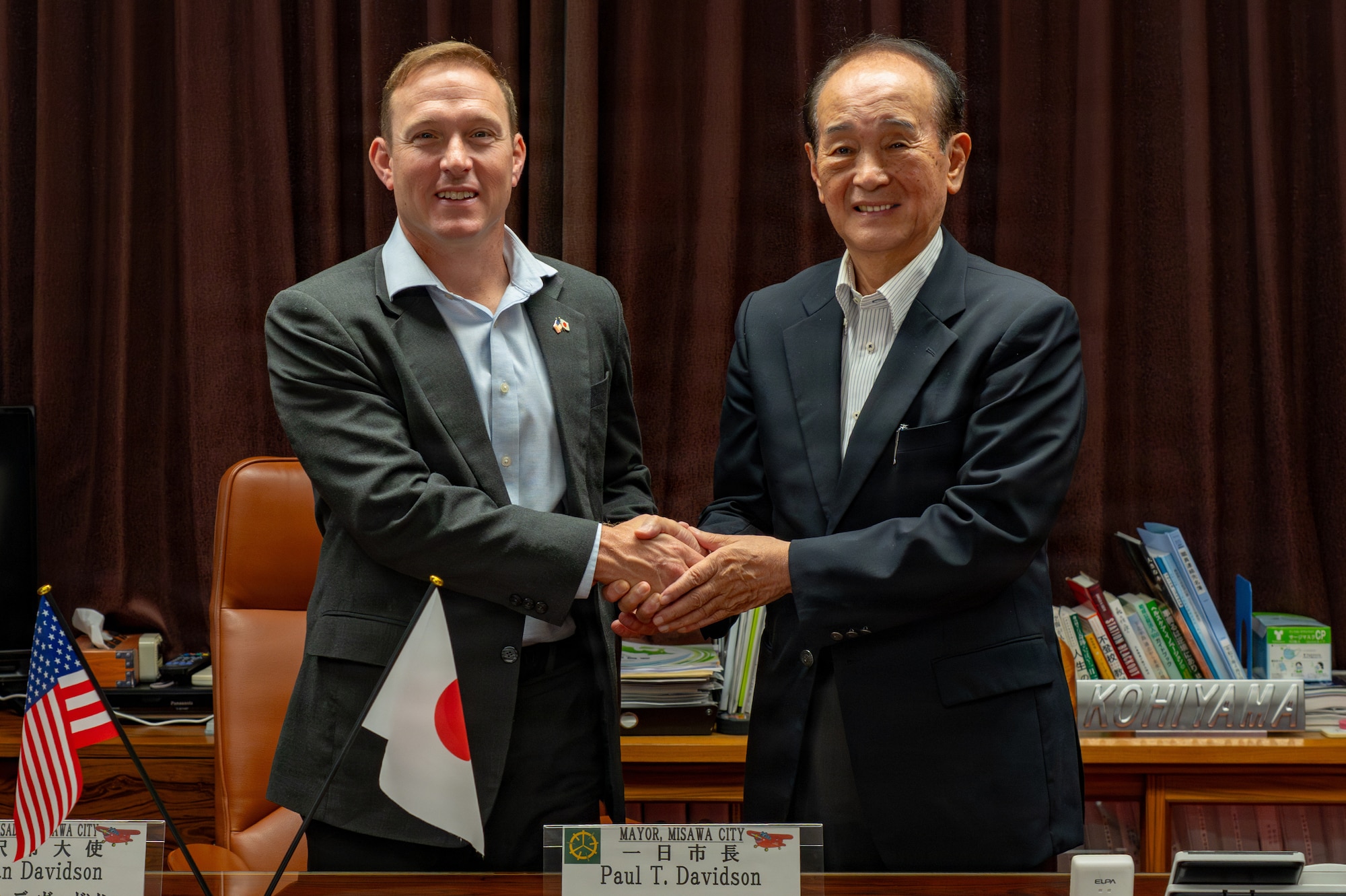U.S. Air  Force Col. Paul Davidson, left, 35th Fighter Wing (FW) commander, shakes hands while posing for a photo with Yoshinori Kohiyama, Misawa City mayor, at the mayor's office in Misawa, Japan, June 16, 2026.