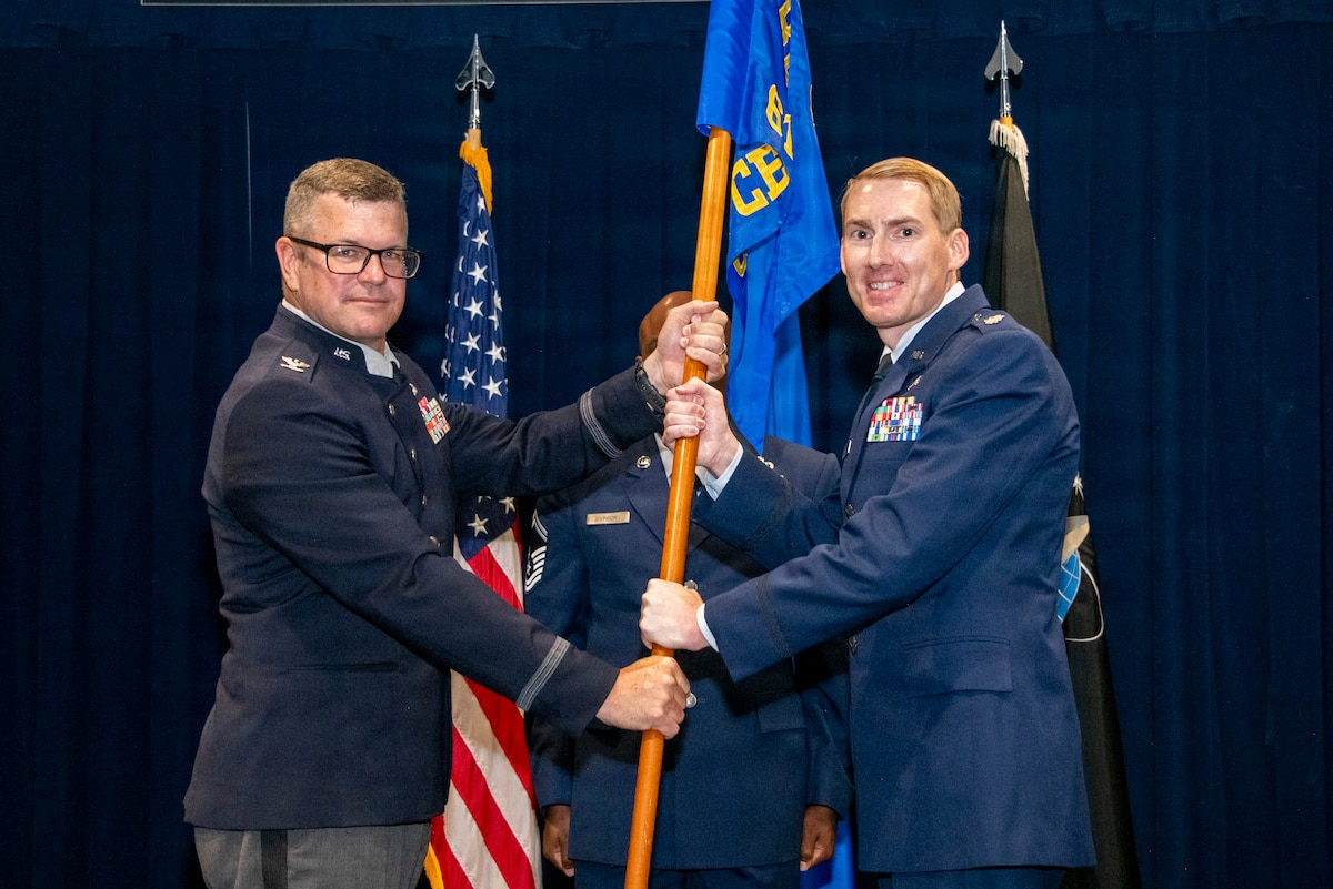 Col. Andrew C. Dermanoski, left, commander of Space Base Delta 3, presents the 61st Civil Engineer and Logistics Squadron guidon to Lt. Col. Brian Greszler, the incoming commander, during a change of command ceremony at Los Angeles Air Force Base, California, June 12, 2026. The 61st Civil Engineer and Logistics Squadron consists of 216 personnel and manages an annual budget of more than $35 million in support of Space Base Delta 3 and Space Systems Command's acquisition mission. (U.S. Space Force photo by Van Ha)
