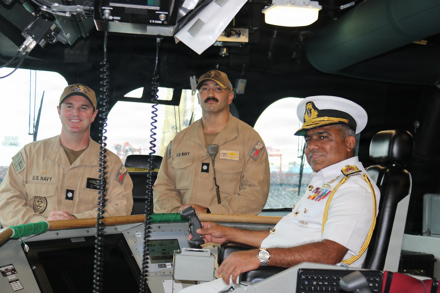 From left, Cmdr. James McLaughlin, commanding officer of Independence-variant littoral combat ship USS Canberra (LCS 30), Cmdr. Ryan Griffith, executive officer of Canberra, and Sri Lanka Navy Rear Adm. Jagath Kumara, commander, Western Naval Area, pose for a photo on the ship’s bridge. Canberra is conducting routine operations in the U.S. 7th Fleet area of operations. (U.S. Navy photo by Operations Specialist 1st Class Anthony Wade).