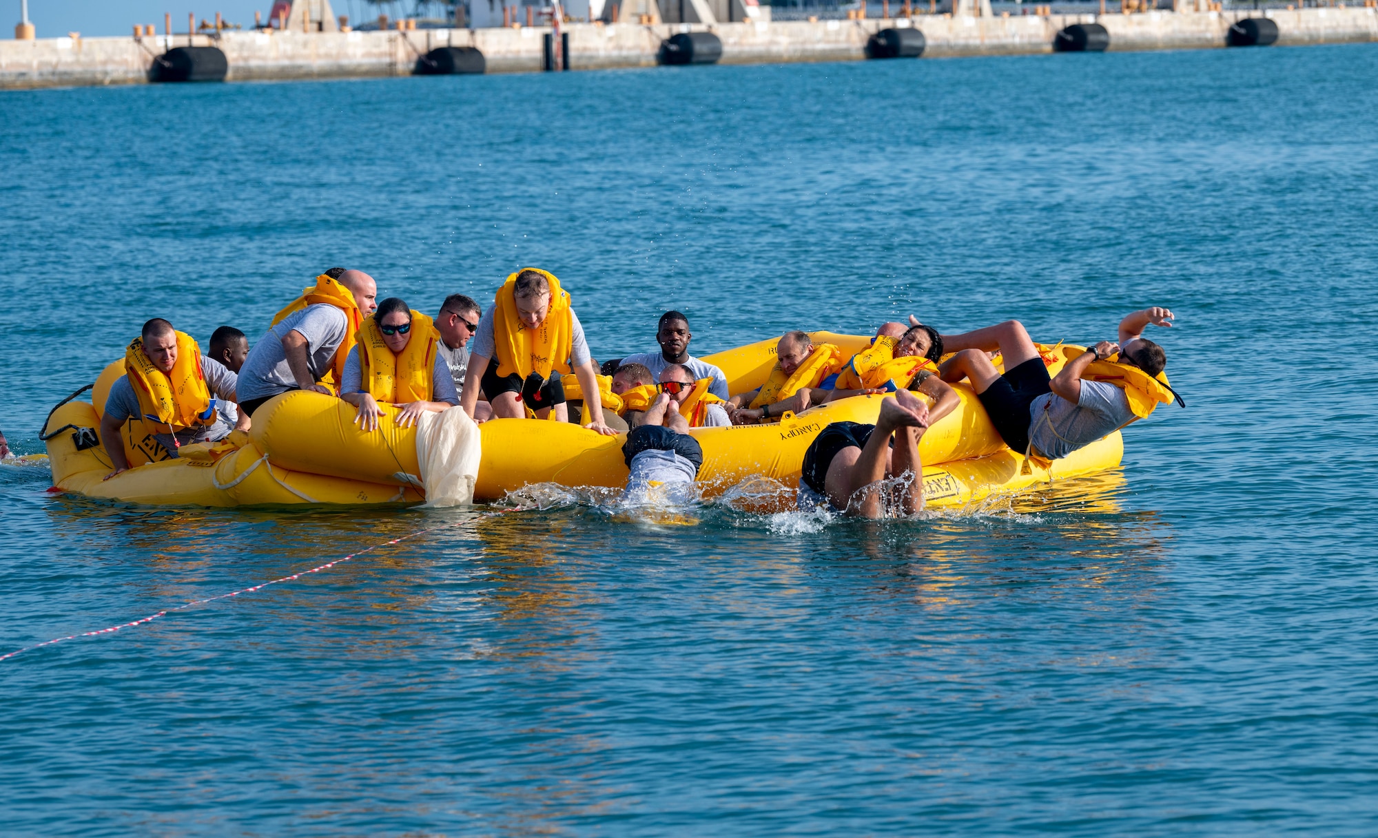 U.S. Airmen assigned to the 183rd Airlift Squadron practice exiting a life raft during Aircrew Flight Equipment Water Survival Training in Key West, Florida, June 2, 2025. The training emphasizes both individual and team survival skills, including raft egress and safety protocols for maritime environments.  (U.S. Air National Guard photo by Senior Airman Damara Burrell)