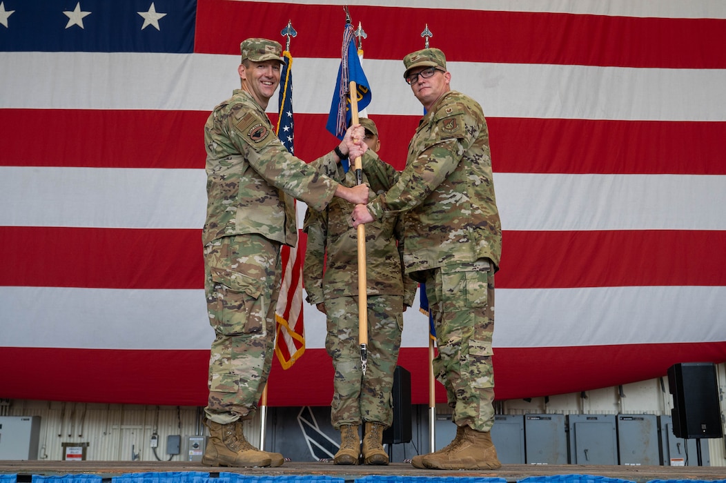 U.S. Air Force Col. John DeLion, left, 8th Fighter Wing commander, passes the 8th Medical Group guidon to Col. Joshua Miller, incoming 8th MDG commander, during an assumption of command ceremony at Kunsan Air Base, Republic of Korea, June 24, 2026. The 8th MDG provides preventive health services and outpatient medical care to more than 2,800 base personnel. (U.S. Air Force photo by Staff Sgt. Cedrique Oldaker)