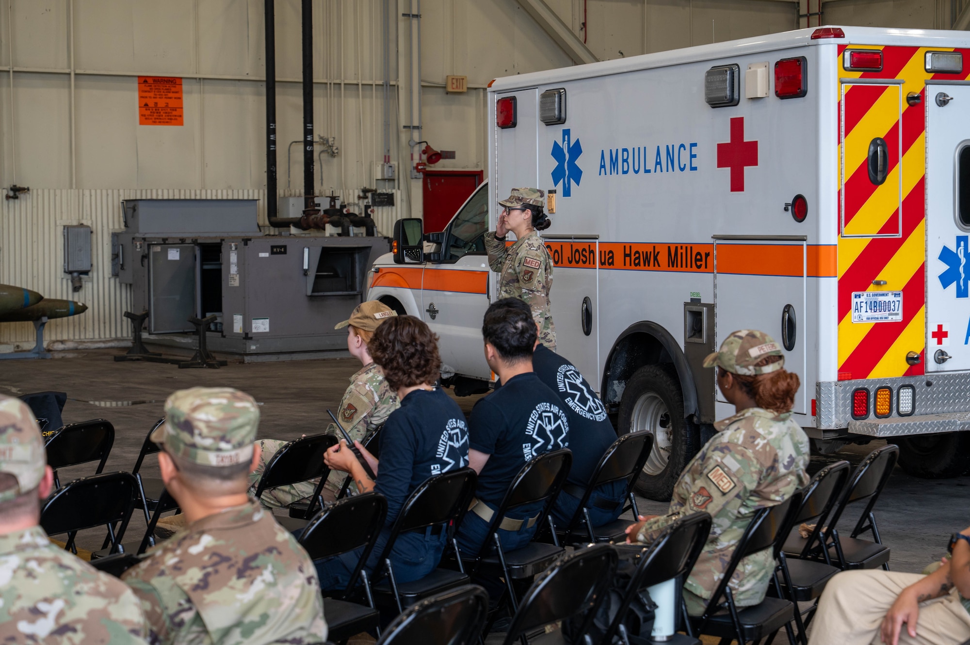 U.S. Air Force Staff Sgt. Moon Gonzales, 8th Medical Group pharmacy noncommissioned officer in charge, unveils Col. Joshua Miller’s name on an ambulance during the 8th MDG assumption of command ceremony at Kunsan Air Base, Republic of Korea, June 18, 2026. The 8th MDG provides preventive health services and outpatient medical care to more than 2,800 base personnel. (U.S. Air Force photo by Staff Sgt. Cedrique Oldaker)