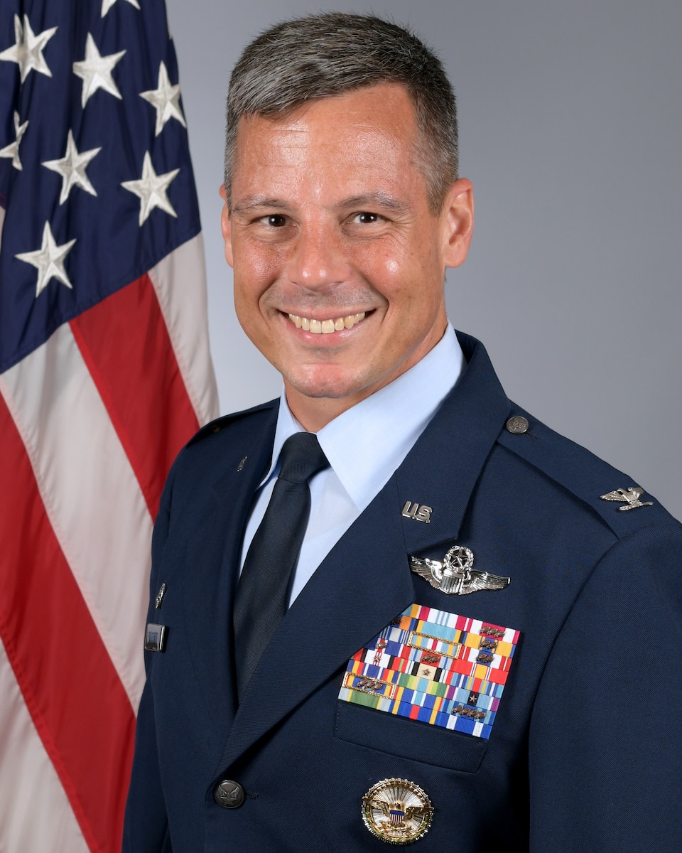 Biography photo in front of a flag.