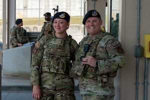 A father and daughter pose for a photo while working a base entry control point together.
