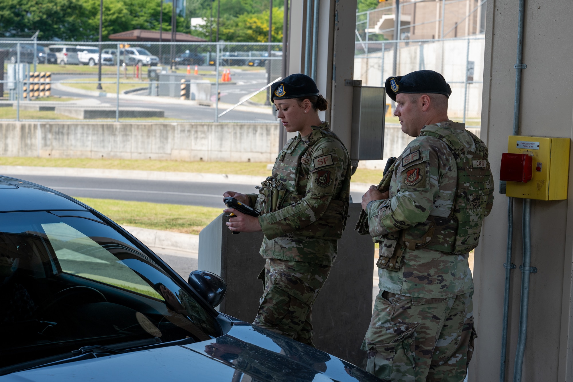 A father and daughter work together scanning IDs at a base entrance.
