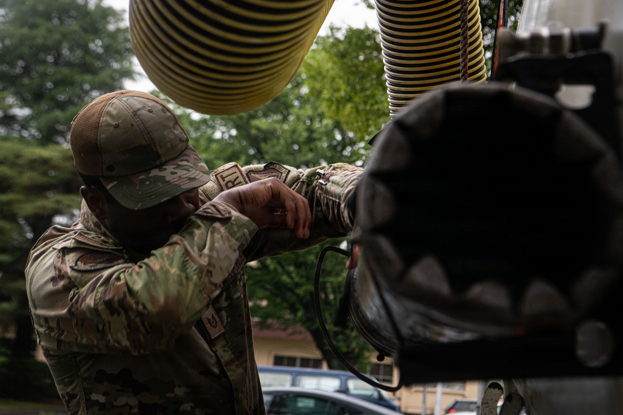 Tech. Sgt. Carter stows away a vacuum hose onto the back of a truck.