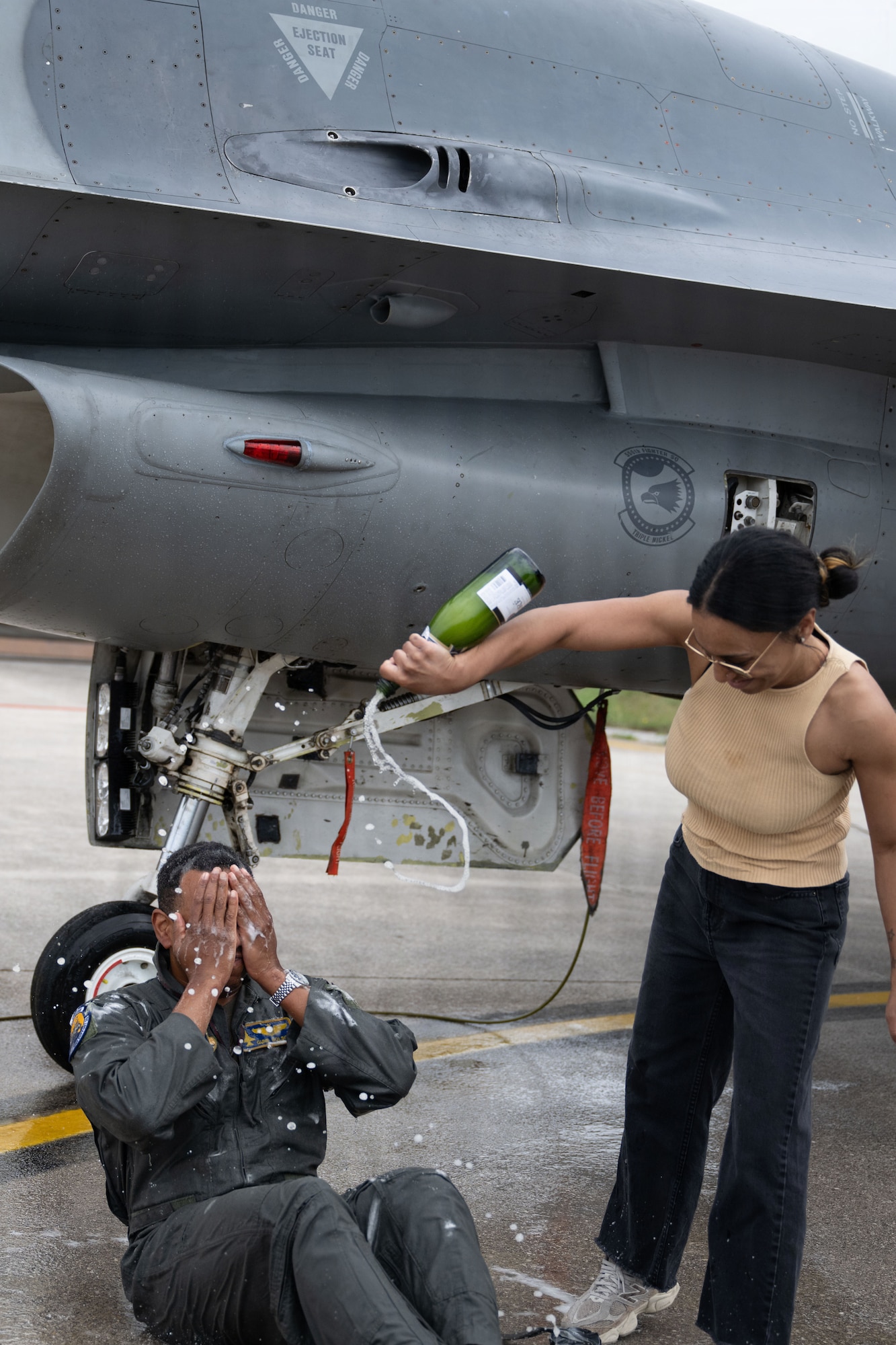 U.S. Air Force Major Andre Golson, 31st Operations Support Squadron weapons and tactics chief, is sprayed with champagne by his wife after completing his final flight at Aviano Air Base, Italy, June 3, 2026.