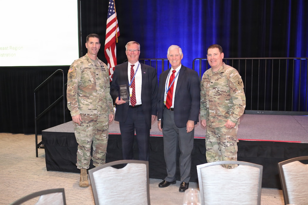 Four Men Pose for award photo.