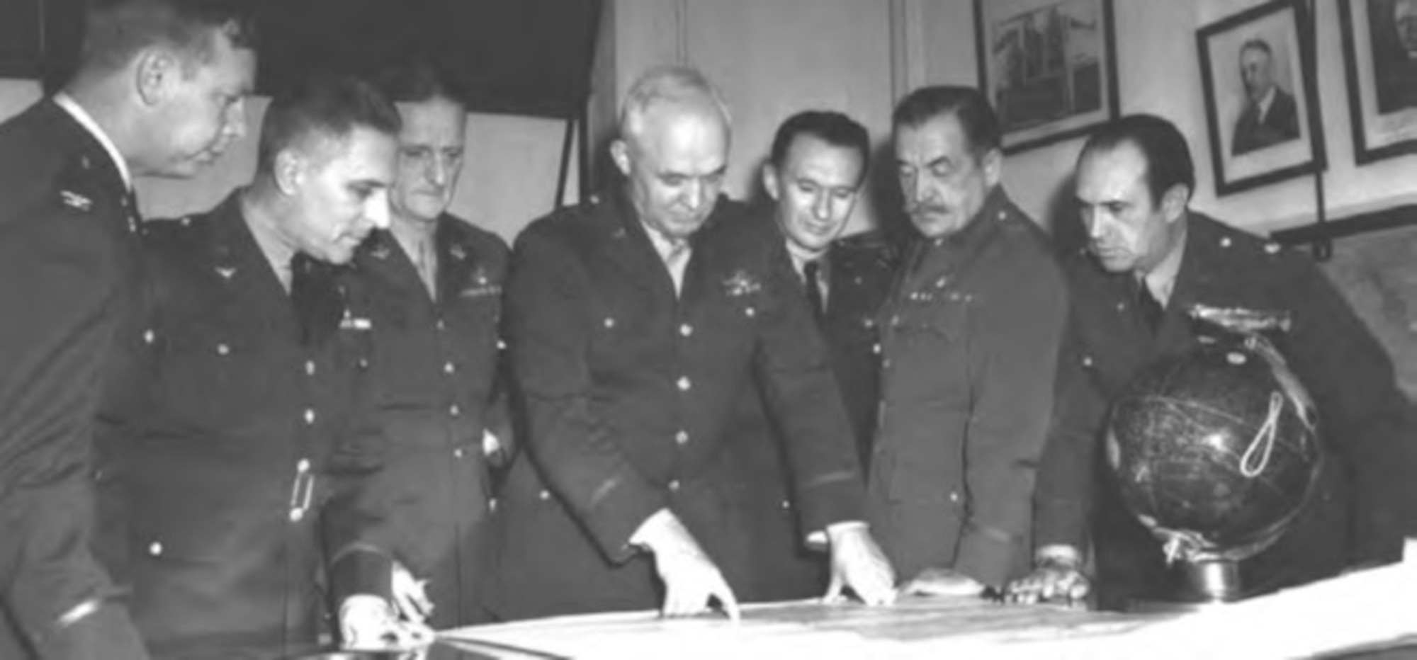 Maj. Gen. Henry Arnold with Air Staff reviews documents and plans in 1941. Pictured from left to right: Lt. Col. Edgar Sorenson, Lt. Col. Harold George, Brig. Gen. Carl Spaatz, Maj. Gen. Henry Arnold, Maj. Haywood Hansell, Jr., Brig. Gen. Martin Scanlon, and Lt. Col. Arthur Vanaman.