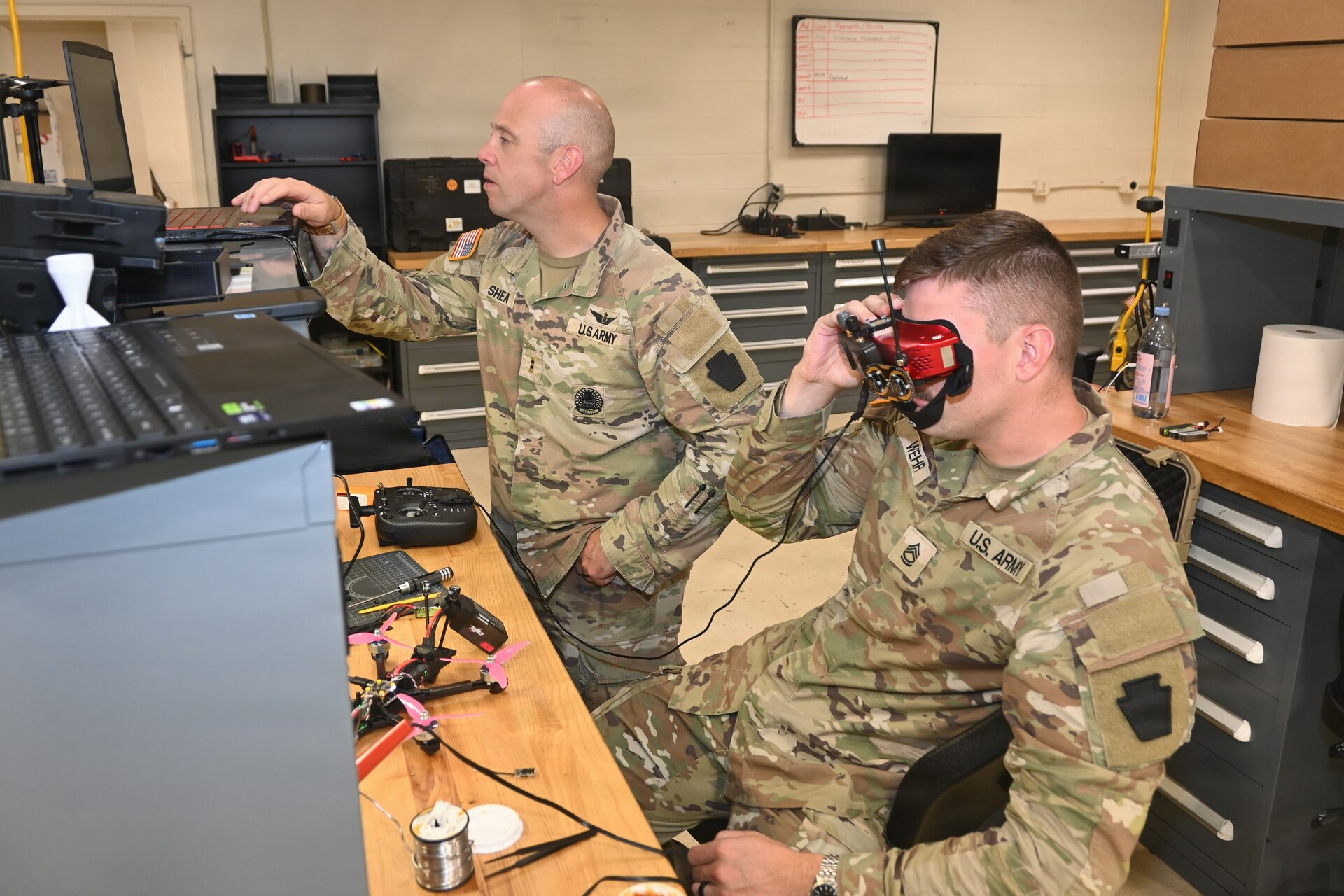 Chief Warrant Officer 2 Nathan Shea, left, officer-in-charge of the Unmanned Aircraft System Training and Innovation Facility at Fort Indiantown Gap, and Sgt. 1st Class Brent Wehr, course manager for the 15X MOS transition course at the UASTIF, trouble-shoot an issue with a UAS on June 10, 2026, at Fort Indiantown Gap, Pennsylvania. (Pennsylvania National Guard photo by Brad Rhen)