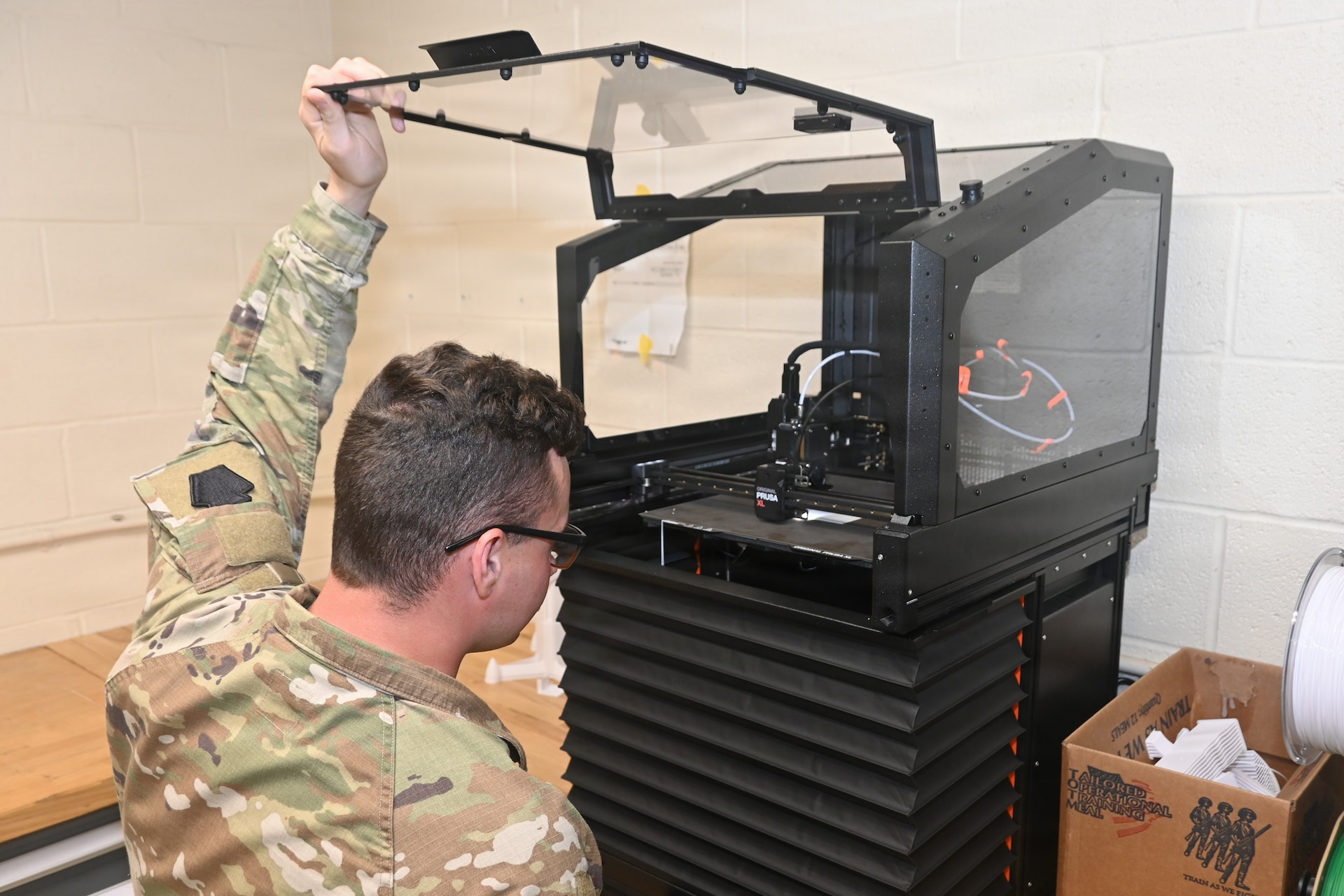 Sgt. Jordan Dietrich, an unmanned aircraft system operator with the 876th Brigade Engineer Battalion, 2nd Infantry Brigade Combat Team, checks on a UAS part that is being printed by a 3D printer June 10, 2026, at the Unmanned Aircraft System Training and Innovation Facility at Fort Indiantown Gap, Pennsylvania. (Pennsylvania National Guard photo by Brad Rhen)