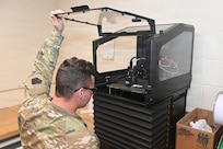 Sgt. Jordan Dietrich, an unmanned aircraft system operator with the 876th Brigade Engineer Battalion, 2nd Infantry Brigade Combat Team, checks on a UAS part that is being printed by a 3D printer June 10, 2026, at the Unmanned Aircraft System Training and Innovation Facility at Fort Indiantown Gap, Pennsylvania. (Pennsylvania National Guard photo by Brad Rhen)