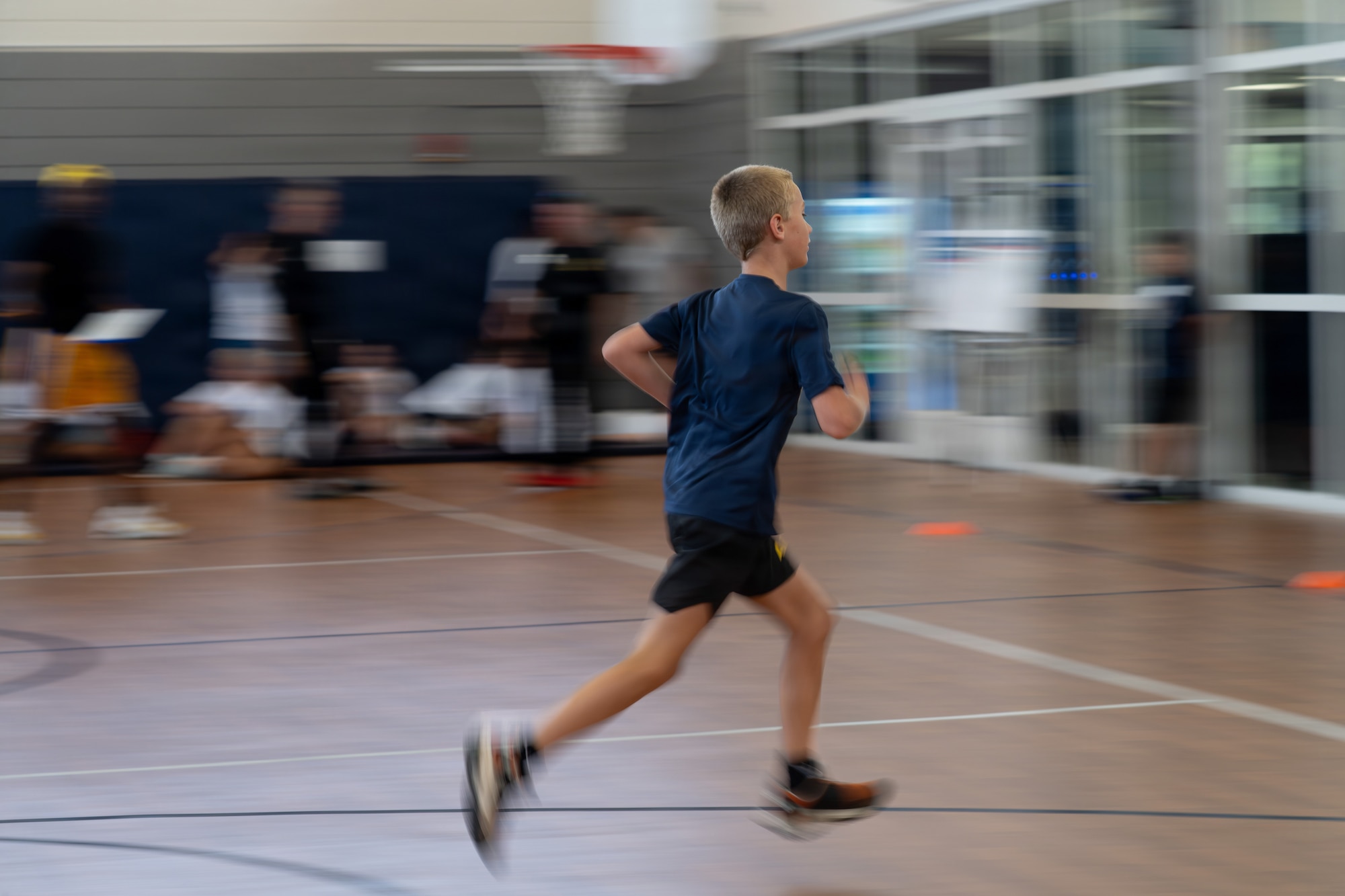 A military child races across the gymnasium floor during the shuttle run portion of the Presidential Fitness Test pilot event at MacDill Air Force Base, Florida, June 12, 2026.