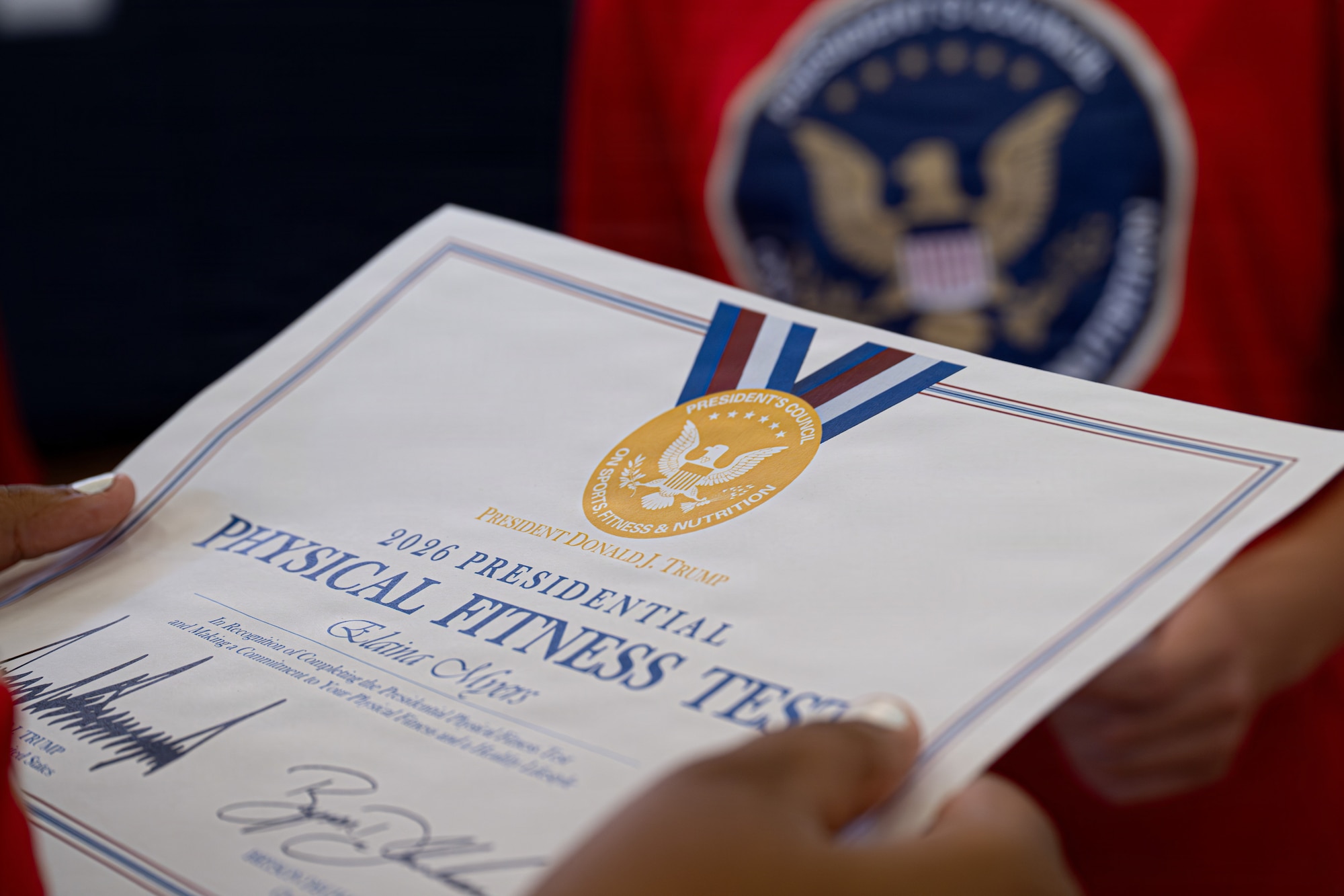 A youth center member holds a 2026 Presidential Physical Fitness Test certificate at MacDill Air Force Base, Florida, June 12, 2026.