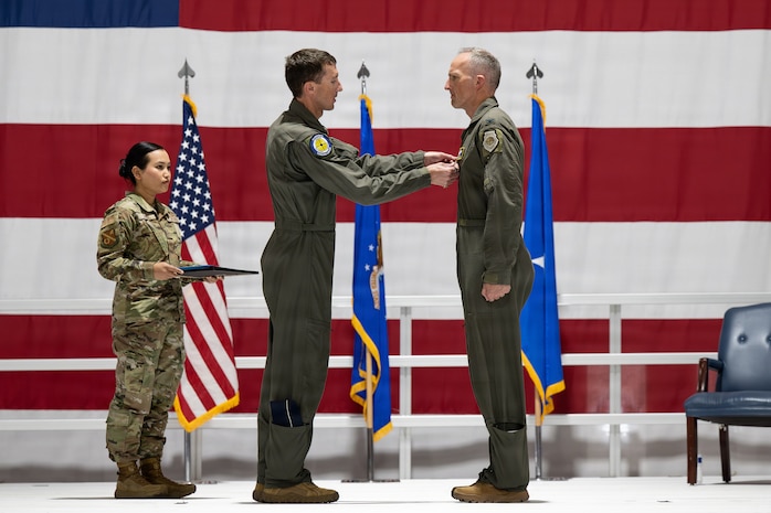 Man pinning a medal on another man