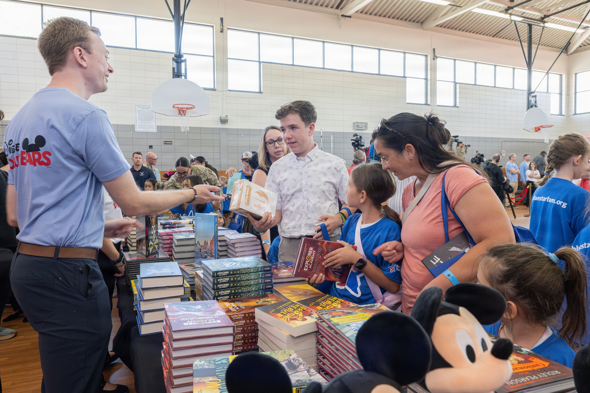 Children of military families receive books during a Blue Star Books event with Disney at MacDill Air Force Base, Florida, June 16, 2026. Approximately 125 children received books and gifts, and had the opportunity to participate in family activities during the event. (U.S. Air Force photo by Airman 1st Class Helen Ly)