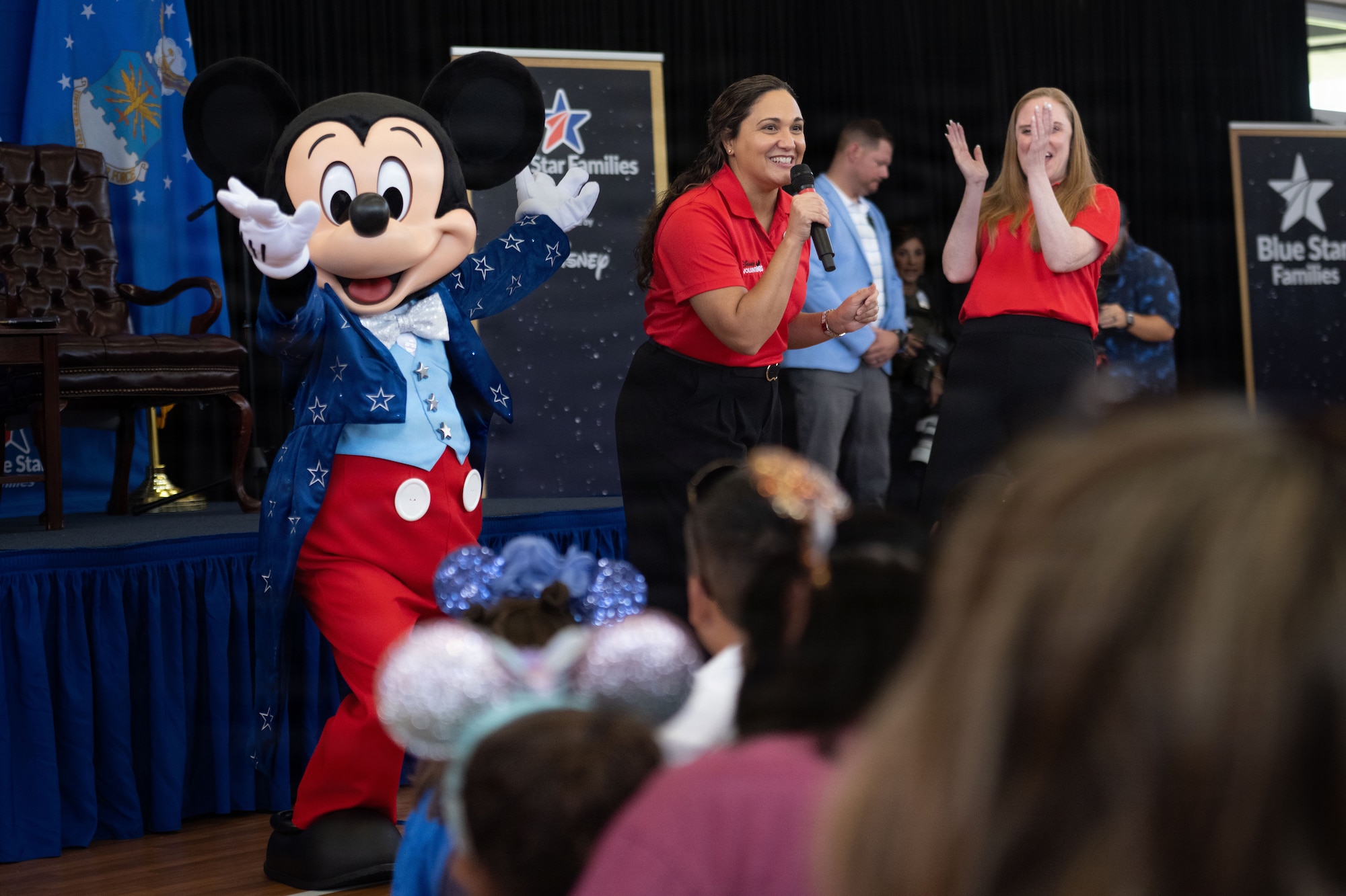 Mickey Mouse performs on stage alongside volunteers during a Blue Star Books event at MacDill Air Force Base, Florida, June 16, 2026. Hosted by Blue Star Families in collaboration with The Walt Disney Company, the event supported Vance’s 2026 Summer Reading Challenge. (U.S. Air Force photo by Airman 1st Class Nelvis Sera)