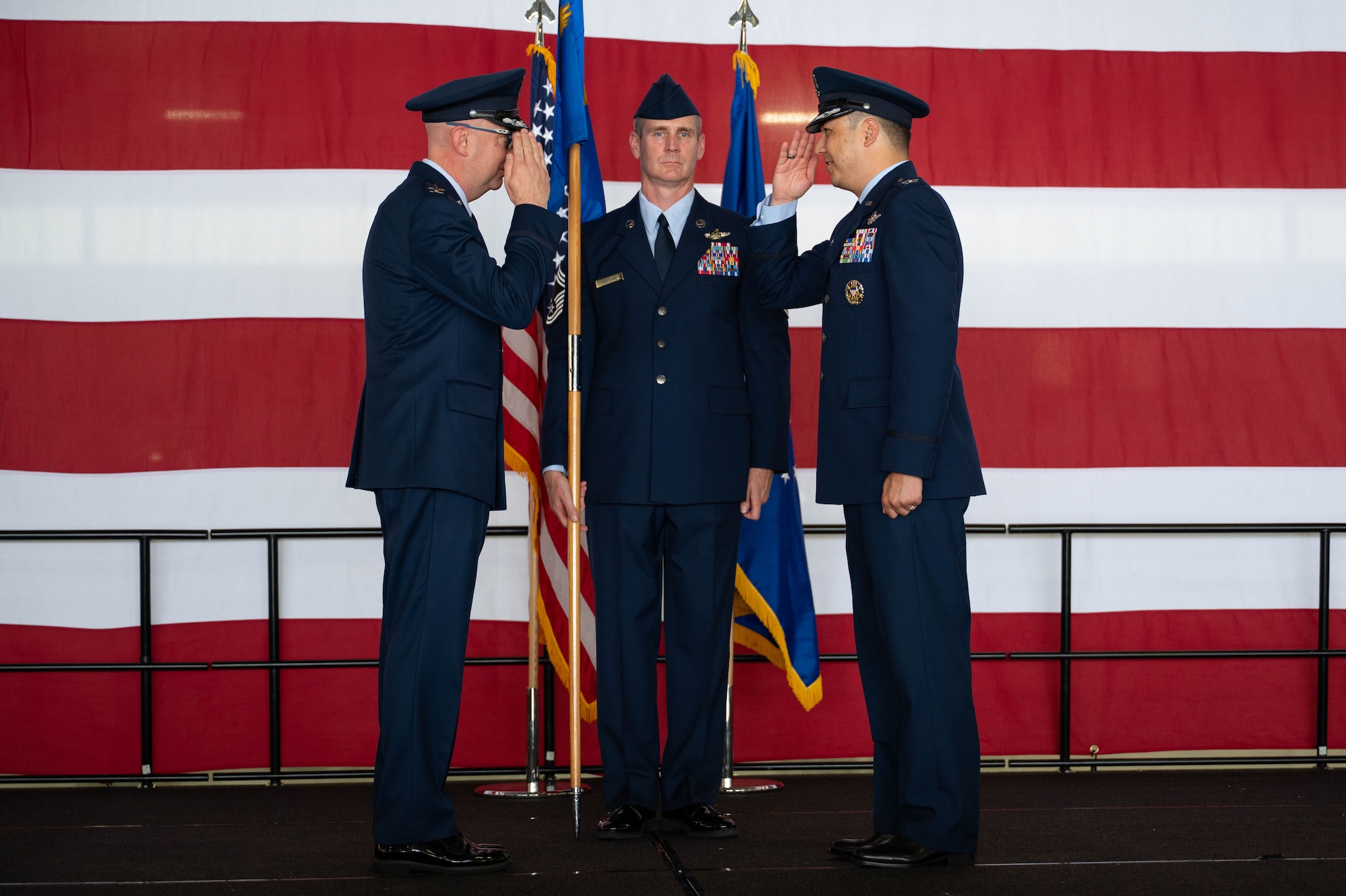 Col. Eric Bissonette renders a salute back to Col. Richard Greig on a stage.