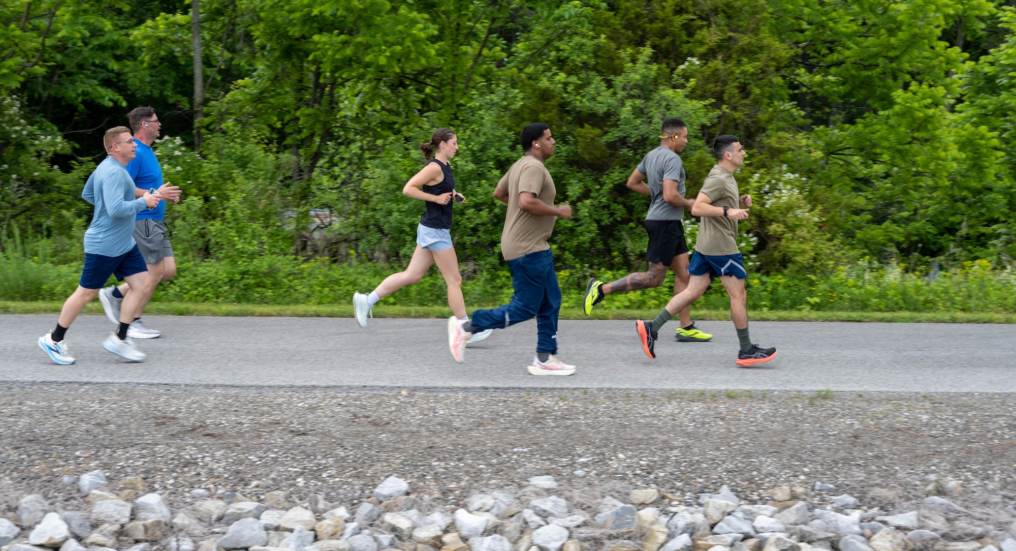 Airmen from the 105th Airlift Wing run on a trail during a group run.