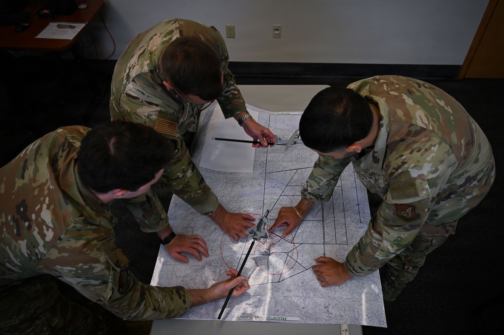 U.S. Airmen review and mark a map where operations during RED FLAG-Alaska 26-2 takes place.